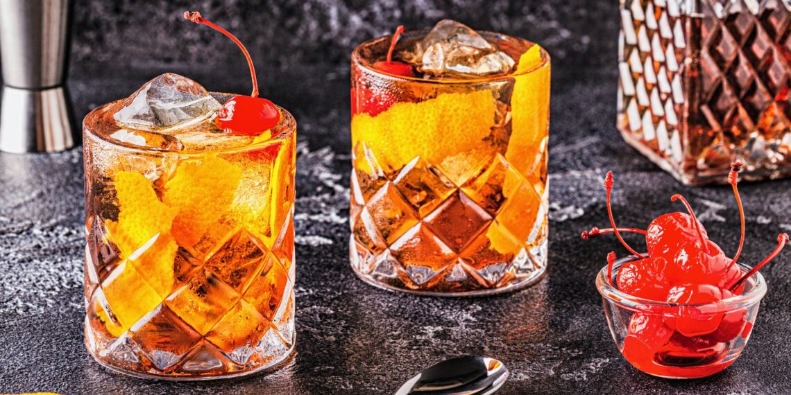 Old Fashioned Cocktail With Cherries And Orange Twist.