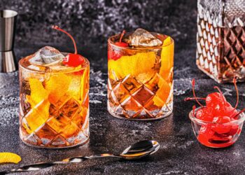Old Fashioned Cocktail With Cherries And Orange Twist.