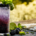 Tall Blackberry Mojito Cocktail With Deep Purple Color, Crushed Ice, Fresh Mint, And Blackberry Garnish