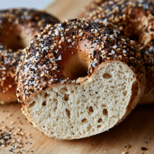 Simple Everything Bagel Recipe - Thefoodiebunch Golden Everything Bagels With Sesame Poppy Seeds And Coarse Salt On A Black Wire Cooling Rack