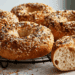 Simple Everything Bagel Recipe - Thefoodiebunch Golden Everything Bagels With Sesame Poppy Seeds And Coarse Salt On A Black Wire Cooling Rack